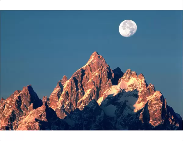 USA, Wyoming, Grand Teton NP. A full moon sets behind the Grand Teton peaks in Grand Teton NP