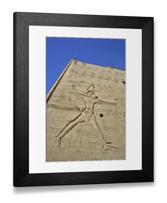Framed Print : Giant figures and hieroglyphs on pylons of main entrance to Temple of Horus, at Edfu