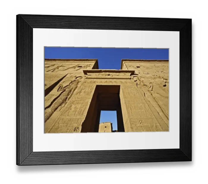 Framed Print : Skyward view of entry pylons and giant figures, Temple of Philae, on Agilika, an Framed Print : Skyward view of entry pylons and giant figures, Temple of Philae, on Agilika, an
