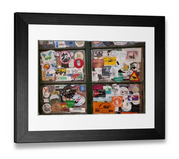 Framed Print : Namibia, Solitaire. Close-up of a bank of windows plastered with stickers Framed Print : Namibia, Solitaire. Close-up of a bank of windows plastered with stickers