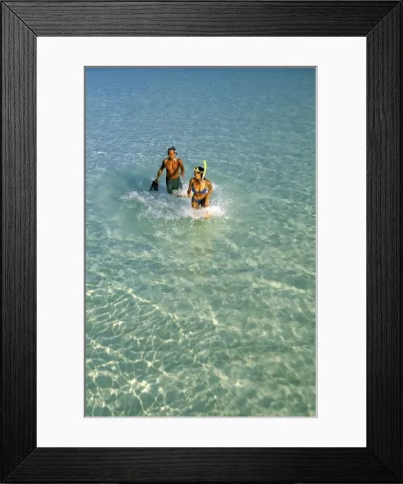 Framed Print : Asia, Maldives. Couple running through waves with diving gear (MR)