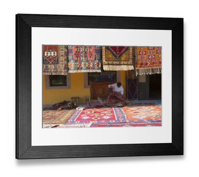 Framed Print : Man sewing the sides of a kilim in front of a local carpets shop, Pergamon (Pergamum Framed Print : Man sewing the sides of a kilim in front of a local carpets shop, Pergamon (Pergamum