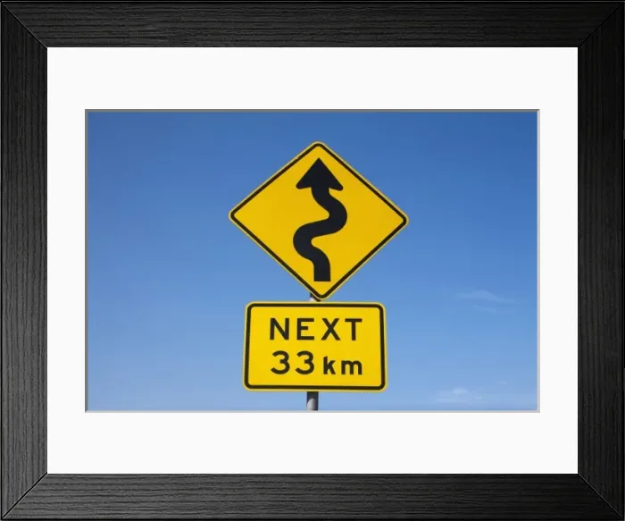 Framed Print : Australia, Victoria, Port Campbell, Winding Road Next 33km warning sign along Great