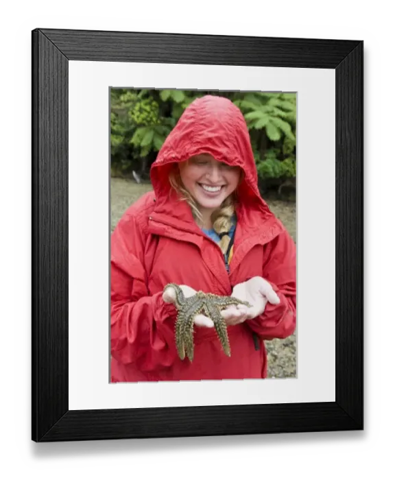 Framed Print : New Zealand, South Island, Marlborough Sounds. Joanna Jensen examining a starfish. (MR) Framed Print : New Zealand, South Island, Marlborough Sounds. Joanna Jensen examining a starfish. (MR)