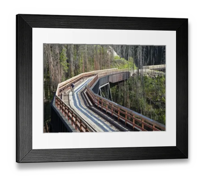 Framed Print : Biker rides across trestle in Myra Canyon on the Kettle Valley Railway bike path near Kelowna Framed Print : Biker rides across trestle in Myra Canyon on the Kettle Valley Railway bike path near Kelowna