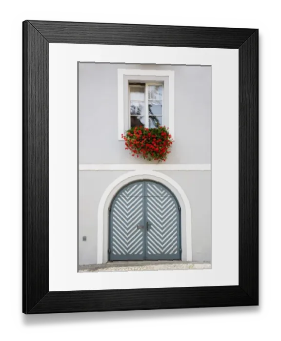 Framed Print : Wels, Upper Austria, Austria - Red flowers are hanging from an open window over a