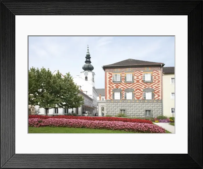 Framed Print : Wels, Upper Austria, Austria - Rows of red and pink flowers border a lawn in front of a building