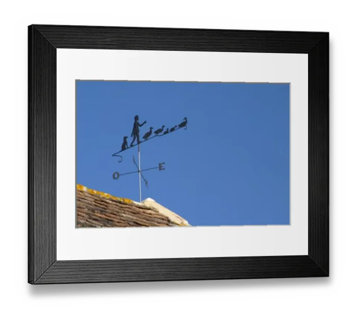 Framed Print : A weathercock weather vane showing a farmer with his or her geese on top of the farm Framed Print : A weathercock weather vane showing a farmer with his or her geese on top of the farm