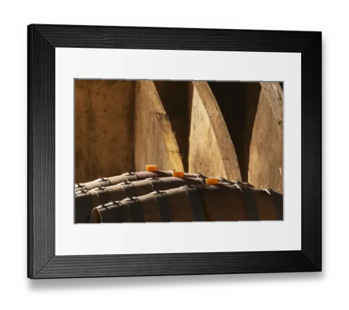 Framed Print : The barrel aging cellar with lines of barriques and dramatic lighting. Chateau Mourgues