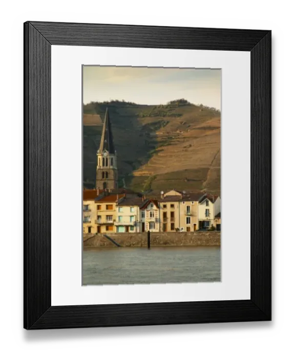 Framed Print : The church in Tain and houses along the river. The Hermitage vineyards on the hill Framed Print : The church in Tain and houses along the river. The Hermitage vineyards on the hill