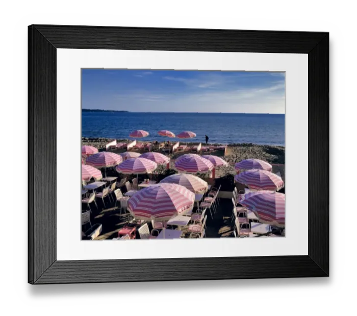 Framed Print : Europe, France, Cannes. Pink stripped umbrellas stand ready for visitors on the beach