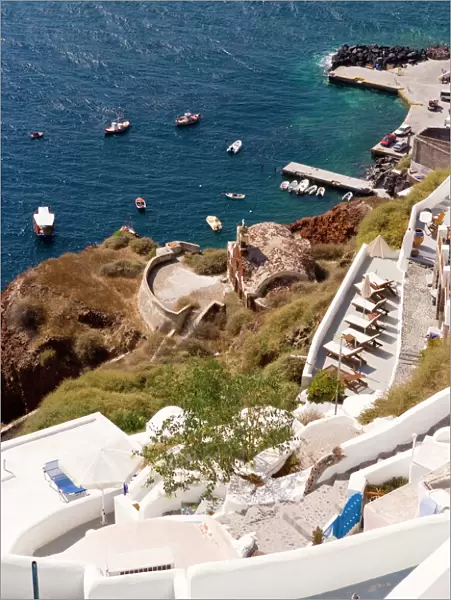 Along the cliff of Oia, view the boats docked in the water, Greece