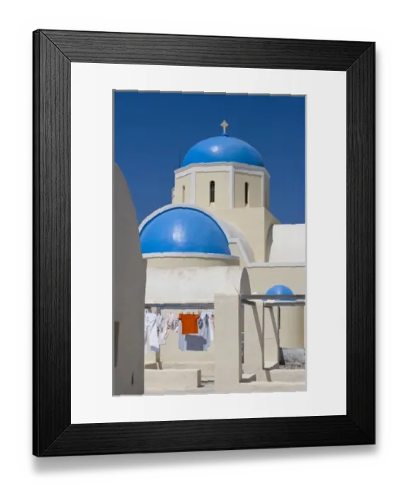 Framed Print : Greece, Santorini, Thira, Oia. Blue Greek Orthodox church domes contrast with drying laundry Framed Print : Greece, Santorini, Thira, Oia. Blue Greek Orthodox church domes contrast with drying laundry