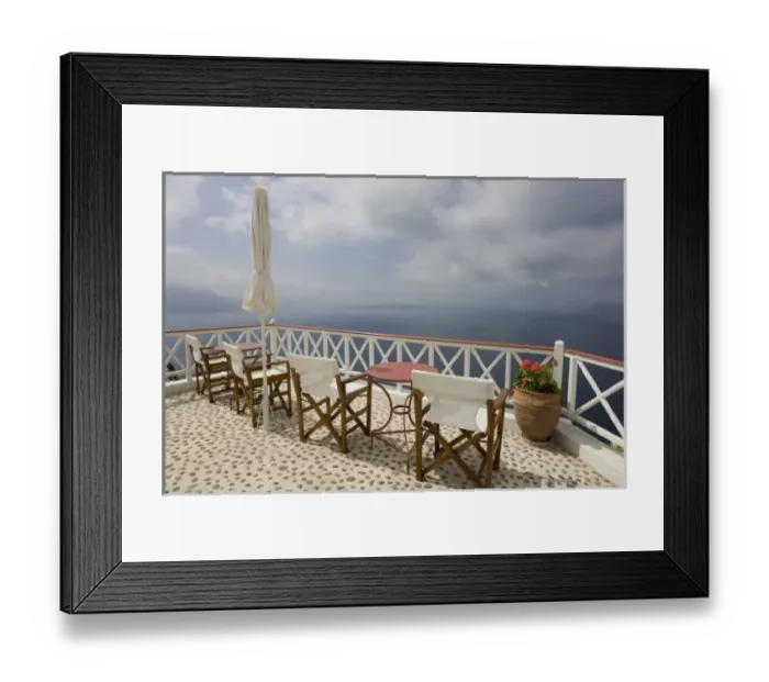 Framed Print : Greece, Santorini, Thira, Oia. Patio tables and chairs on pebbled deck overlooking misty sea Framed Print : Greece, Santorini, Thira, Oia. Patio tables and chairs on pebbled deck overlooking misty sea