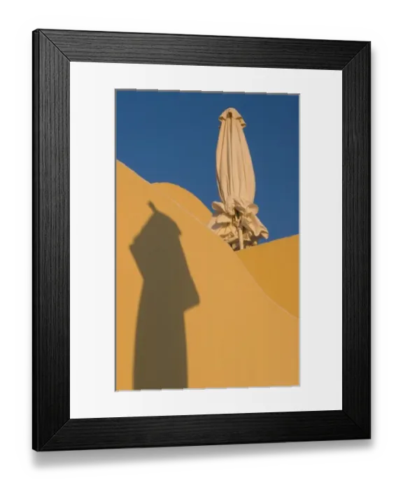 Framed Print : Greece, Santorini. Folded sun umbrella and shadow of another umbrella against yellow wall Framed Print : Greece, Santorini. Folded sun umbrella and shadow of another umbrella against yellow wall