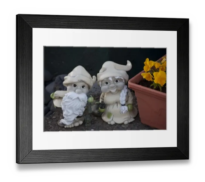 Framed Print : Fanciful troll figures by a flower box at the entrance to an Icelandic home