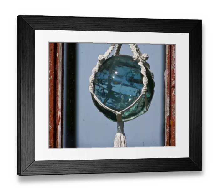 Framed Print : Old-fashioned glass float used in fishing nets hangs in window near Latrabjerg, Iceland Framed Print : Old-fashioned glass float used in fishing nets hangs in window near Latrabjerg, Iceland