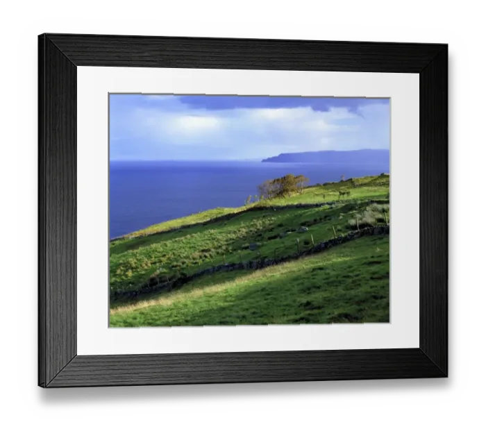 Framed Print : The sun lights the verdant headlands of Antrim Coast, Northern Ireland