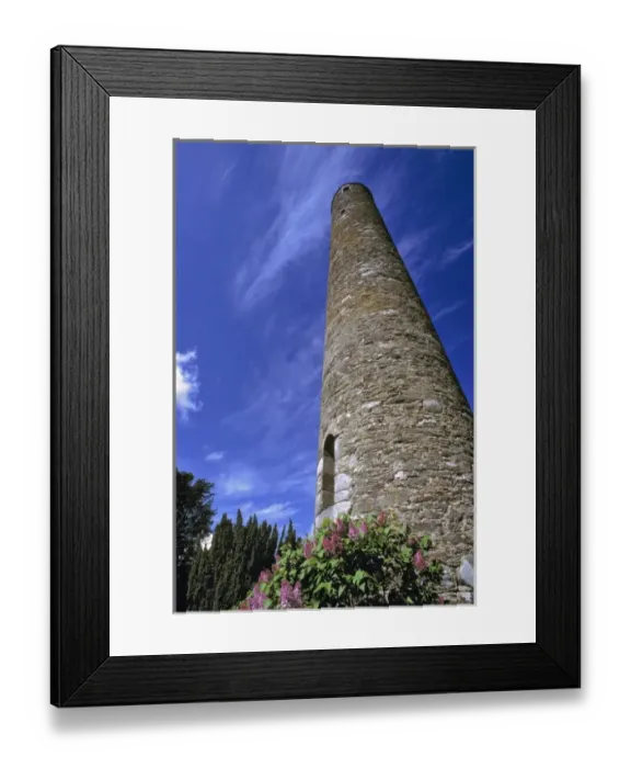 Framed Print : Europe, Ireland, Glendalough. A tall, round tower reaches to the blue, cloud-brushed