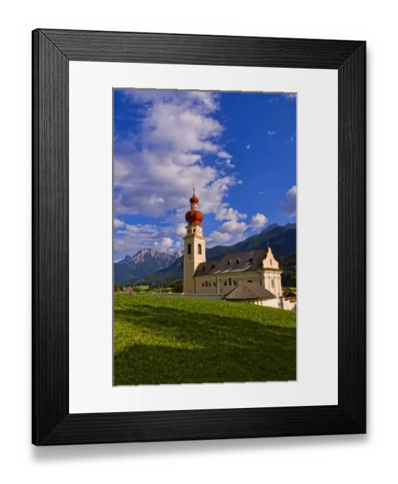 Framed Print : Beautiful St Stephan Church with steeple with fabulous Dolomites mountains behind Framed Print : Beautiful St Stephan Church with steeple with fabulous Dolomites mountains behind