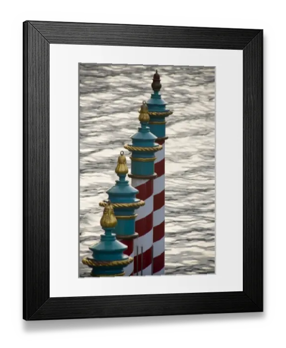 Framed Print : Italy, Venice. A line of gondola parking poles striped in red and white