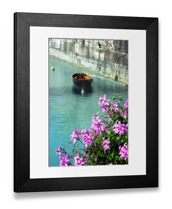 Framed Print : A boat drifts in a canal in Peschiera del Garda on the shores of Lake Garda, Italy Framed Print : A boat drifts in a canal in Peschiera del Garda on the shores of Lake Garda, Italy