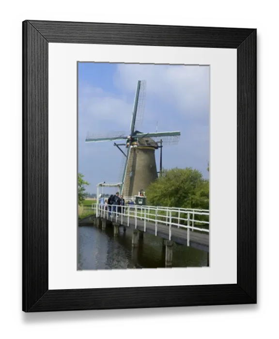Framed Print : Europe, Netherlands, Holland, Kinderdijk, American tourist visit a windmill open