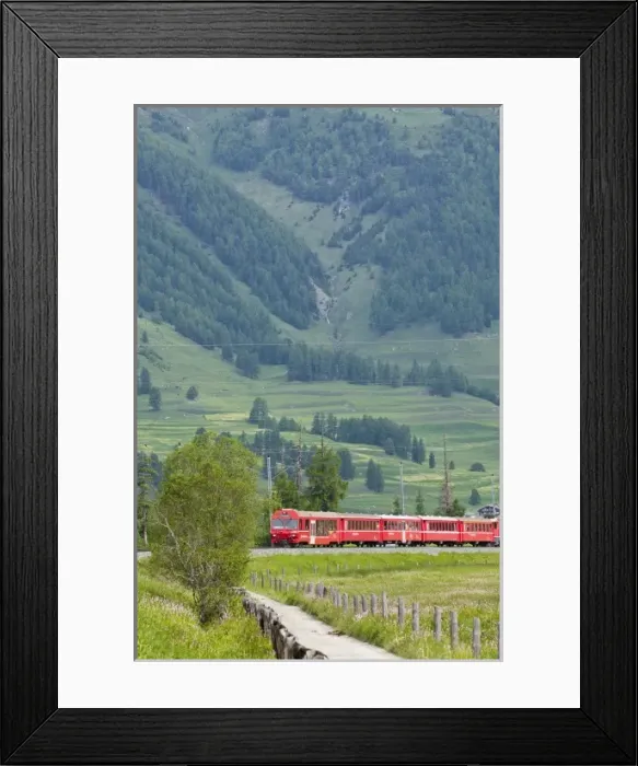 Framed Print : Red train crossing Swiss countryside