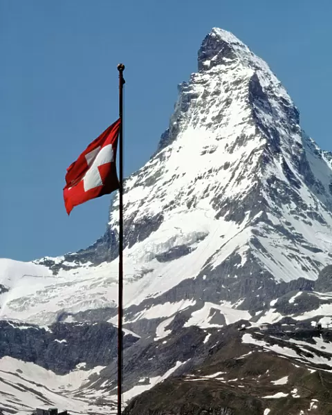 Europe, Switzerland, Matterhorn. The Swiss flag flies proudly at the base of the
