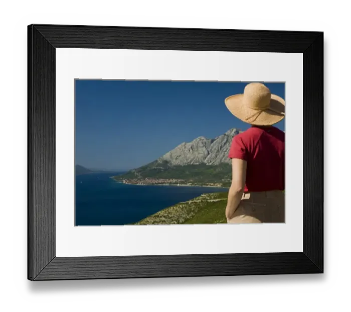 Framed Print : Croatia, Dalmatia, Female tourist in straw hat gazes at lush fields and town of Orebic Framed Print : Croatia, Dalmatia, Female tourist in straw hat gazes at lush fields and town of Orebic