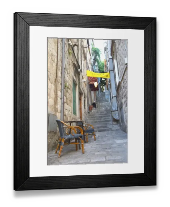 Framed Print : View from the Prijeko street up a narrow street with steep stairs. Two rattan chairs Framed Print : View from the Prijeko street up a narrow street with steep stairs. Two rattan chairs