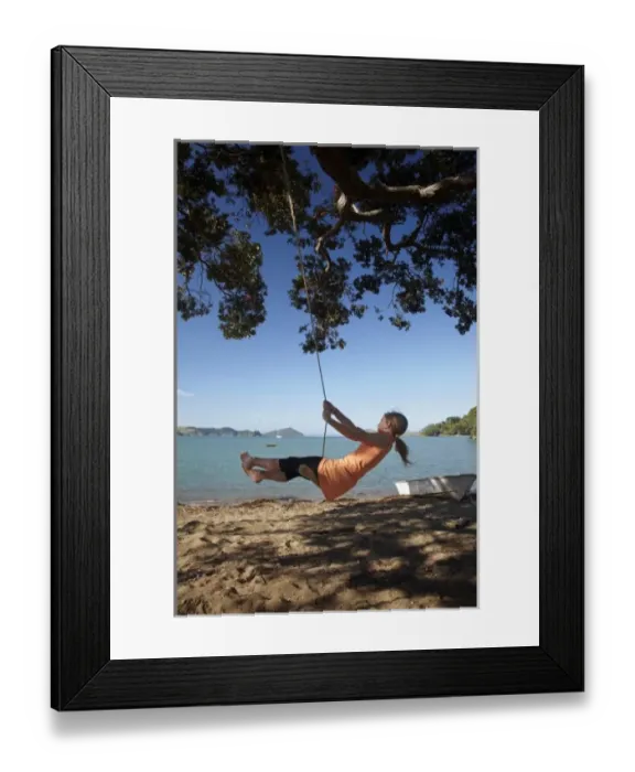 Framed Print : Young Girl on Rope Swing under Pohutukawa Tree, Oamaru Bay, Coromandel, North Island Framed Print : Young Girl on Rope Swing under Pohutukawa Tree, Oamaru Bay, Coromandel, North Island