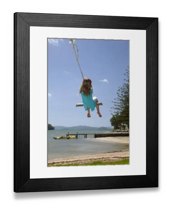 Framed Print : Young girl on rope swing, Sandspit, near Warkworth, Auckland Region, North Island