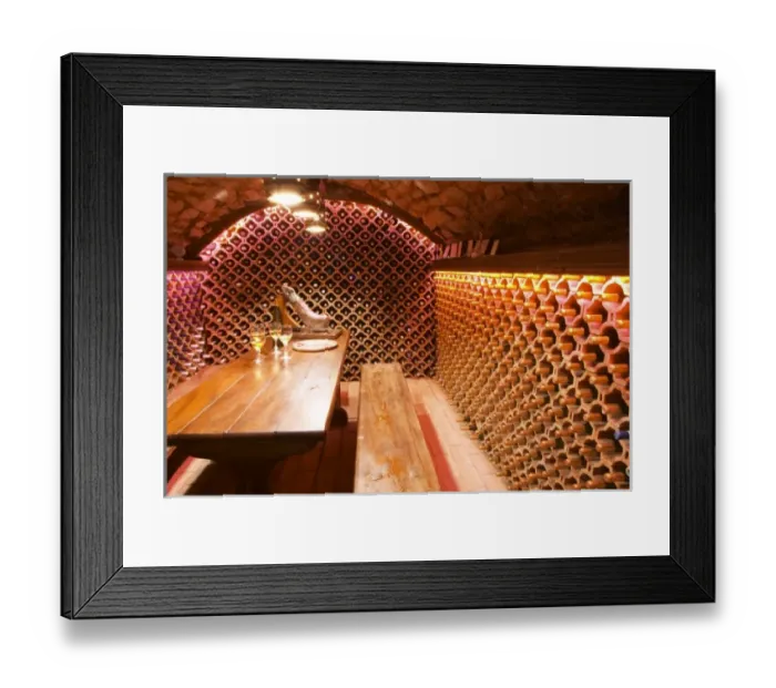 Framed Print : The wine cellar and tasting room, walls are lined with bottles stacked in terracotta