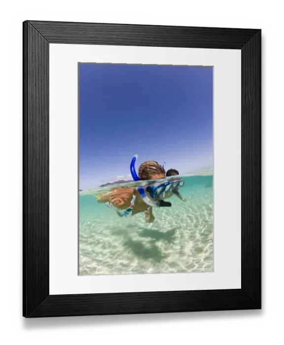 Framed Print : couple (age 23 and 24) enjoying snorkeling the clear tropical waters of a remote island