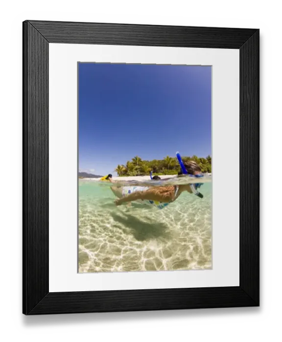 Framed Print : couple (age 23 and 24) enjoying snorkeling the clear tropical waters of a remote island