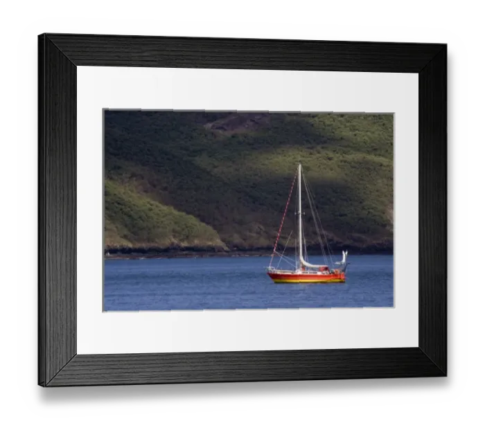 Framed Print : French Polynesia, Marquesas Islands, Nuku Hiva. Brightly colored sailboat at anchor off the coast