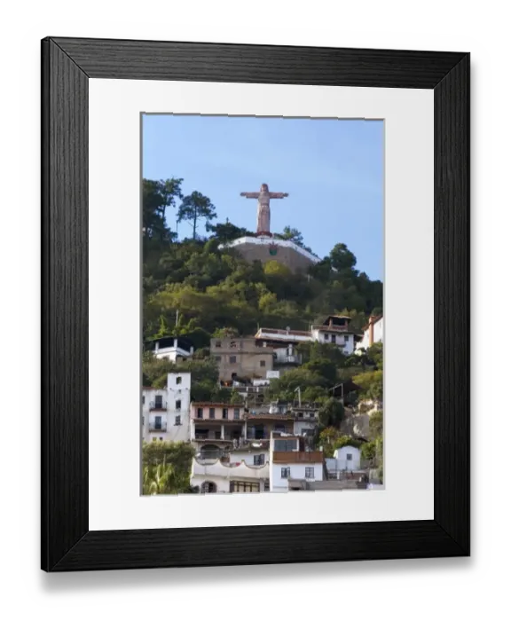 Framed Print : A Christ statue sits above homes built on the hillside at Taxco in the State of Guerrero, Mexico
