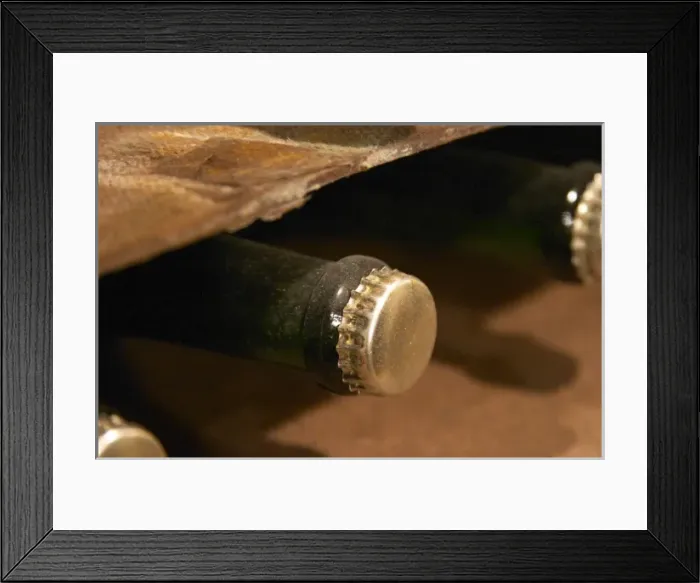 Framed Print : Bottles of sparklling wine sur lattes getting bottle age with a beer style crown
