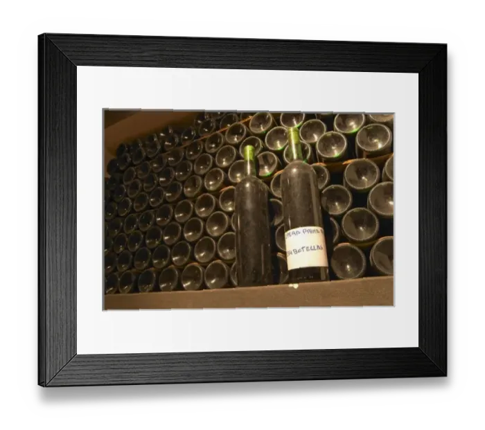 Framed Print : In the bottle aging wine cellar, bottles lying down and two standing with a label Framed Print : In the bottle aging wine cellar, bottles lying down and two standing with a label