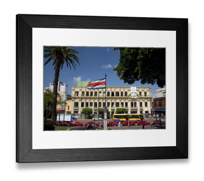 Framed Print : Costa Rican flag, red taxicabs, and yellow buses at the Parque Central in the city of San Jose Framed Print : Costa Rican flag, red taxicabs, and yellow buses at the Parque Central in the city of San Jose