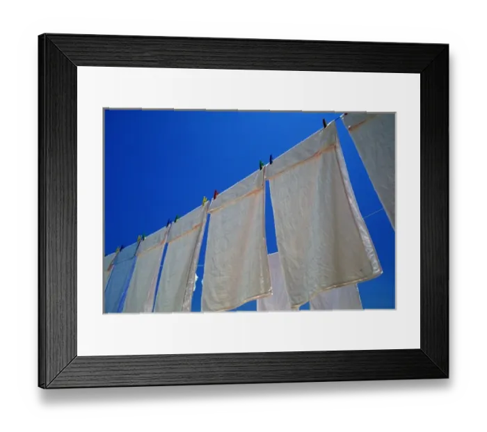 Framed Print : Oia, Santorini, Greece, White linens drying on a clothesline against the blue sky