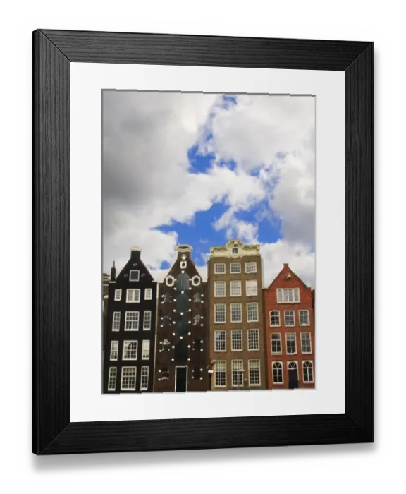 Framed Print : View of the unique architecture and gabled homes along a colorful canal with fluffy