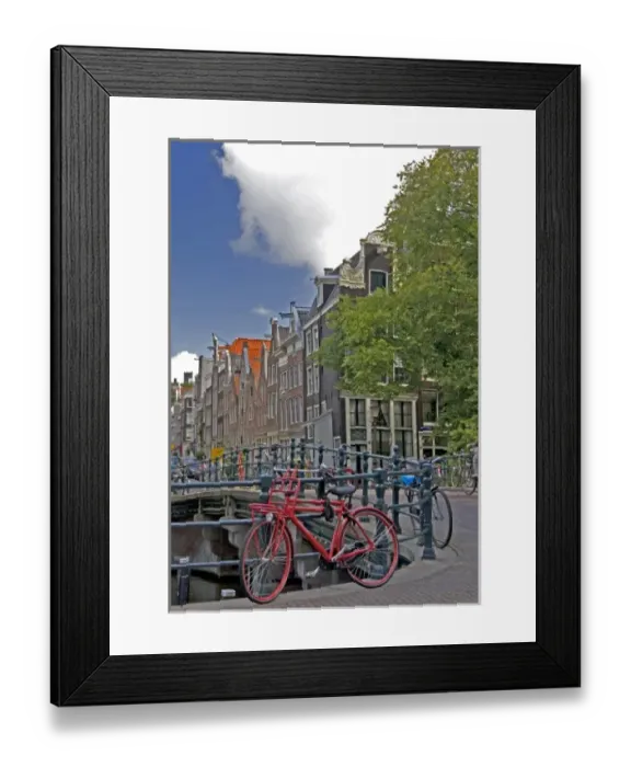Framed Print : Bright red bike parked along the edge of a canal bridge along with many other colorful Framed Print : Bright red bike parked along the edge of a canal bridge along with many other colorful