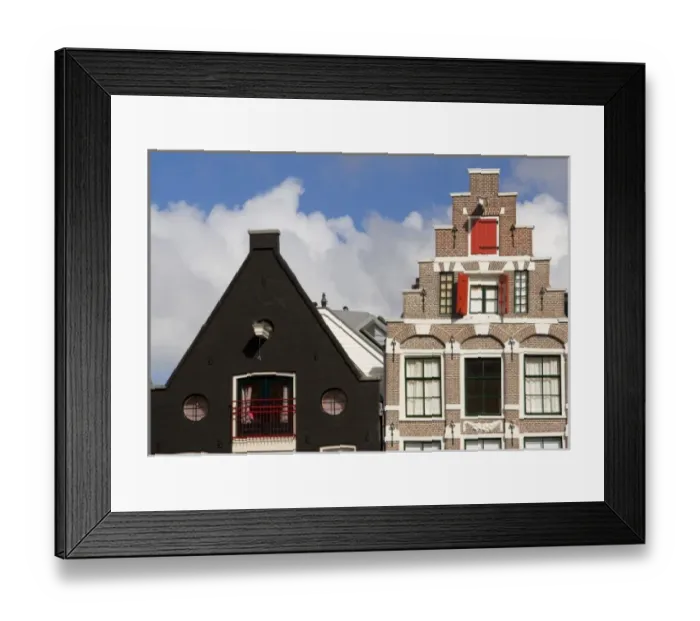 Framed Print : Colorful buildings with ornate facades and windows with red shutters against a blue Framed Print : Colorful buildings with ornate facades and windows with red shutters against a blue