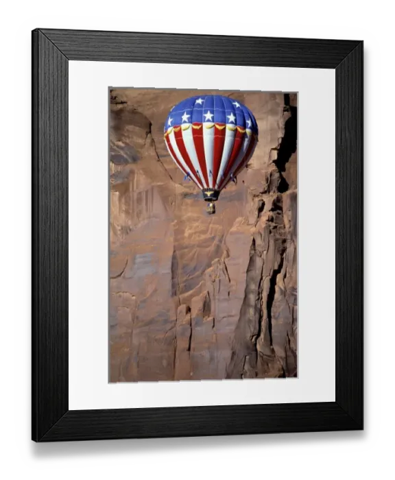 Framed Print : USA, Utah, Monument Valley. A patriotic hot-air balloon floats by a red rock wall Framed Print : USA, Utah, Monument Valley. A patriotic hot-air balloon floats by a red rock wall