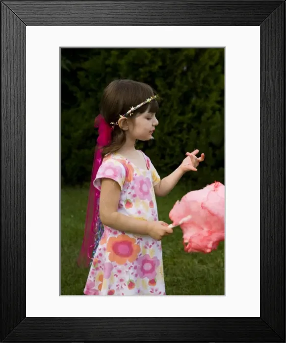 Framed Print : A young girl (age 5) enjoys cotton candy at the Quechee Balloon Festival, Quechee, Vermont