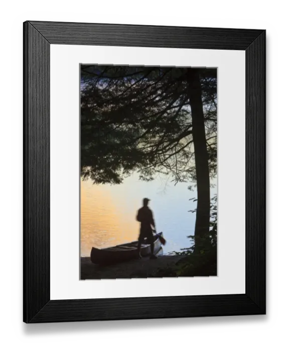 Framed Print : A man next to his canoe at Zack Woods Pond, Hyde Park, Vermont. Early morning