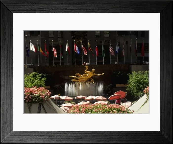 Framed Print : Famous RCA gold statue in Rockefeller Center with flags and flowers and cafe in New York City USA Framed Print : Famous RCA gold statue in Rockefeller Center with flags and flowers and cafe in New York City USA