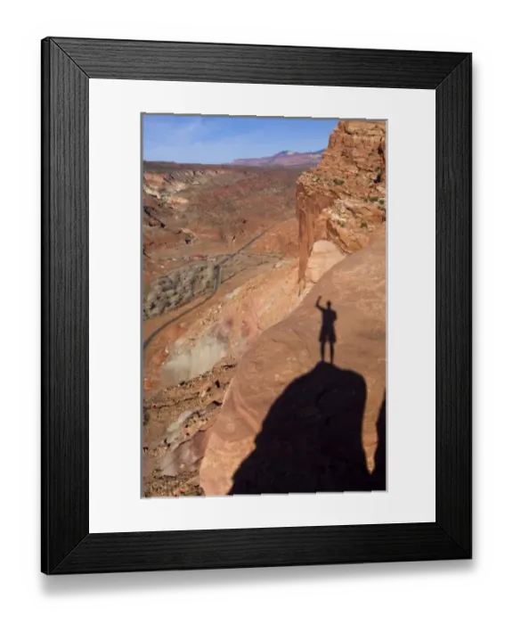 Framed Print : USA, Utah, Capitol Reef National Park. The shadow of a hiker standing on cliffs above the highway